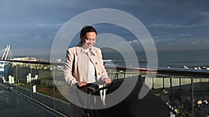 Slow motion Young mother pushing baby pram with sleeping child, walking on the coastline outdoors