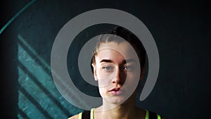 Slow motion young serious female boxer in wrapped hands warming up, jumping on skipping rope closeup