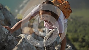 slow motion young woman hiker rock climber climbs up on cliff on mountain over beautiful sea coast in Turkiye. active