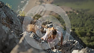 slow motion young woman hiker rock climber climbs up on cliff on mountain over beautiful sea coast in Turkiye. active