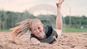 Slow motion: a Young woman jumping in the fall hits the ball on the sand. Volleyball player makes a team and plays the