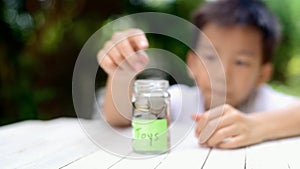 Slow motion zoom in of Boy saving coin