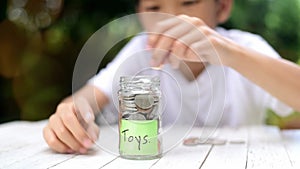 Slow motion zoom in of Boy saving coin