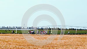 A slow moving close to a ground of a crop duster biplane used to fertilize field