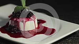 A slow moving footage of a panna cota cake on a rotating table