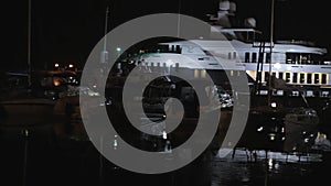 Slow night panorama of yachts, ships, boats in sea port.