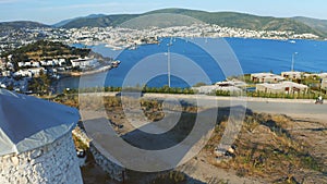 Slow rising shot over ancient windmills. Releaving bay and resort town Bodrum. Welcome to Turkey concept