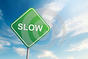 Slow road sign with blue sky and cloud background