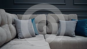 Slow shot of a gray couch with two gray and two blue pillows. 4k video