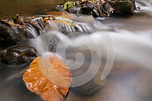 Slow shutter capturing flowing water of cascading trickling stream in smooth silky white