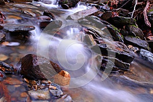 Slow Shutter Speed Photography of a Small River with Rocks in the Woods of the Mountains Park.