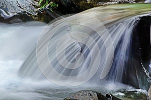 Slow silky waters run over a boulder in the Smokies. photo