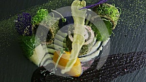 Slow zoom in at trendy decorated fish rolls spinning around on black plate