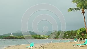 slowly panorama of golden sandy beach with empty resort sunbeds in sunny daytime