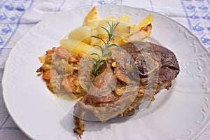 Slowly roasted spring lamb leg with rosemary and garlic served with sweet glazed onions, carrots, apples and baked potatoes