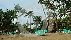 slowly round panorama of tropical sandy beach with empty resort sunbeds