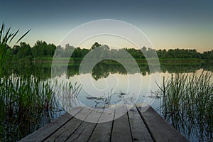 Slowly walking over a large wooden jetty into a lake and flying over the water afterwards