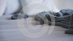 Slowmo of bathrobe and high-heels falling on white bed. Unknown person throwing clothes and shoes on bedding in bedroom