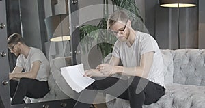 Slowmo of young Caucasian actor rehearsing role at home or at backstage. Emotional handsome brunette man reading text