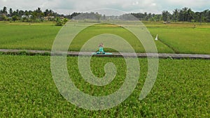 Slowmotion aerial shot of a young woman doing meditation for Muladhara chakra in a Balinese way