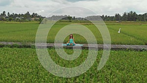 Slowmotion aerial shot of a young woman doing meditation for Muladhara chakra in a Balinese way