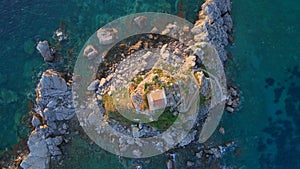 Slowmotion aerial video. The Sveta Nedelja - Christian church on a tiny island in the sea close to the city of Petrovac