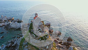 Slowmotion aerial video. The Sveta Nedelja - Christian church on a tiny island in the sea close to the city of Petrovac