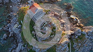 Slowmotion aerial video. The Sveta Nedelja - Christian church on a tiny island in the sea close to the city of Petrovac