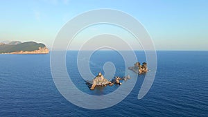 Slowmotion aerial video. The Sveta Nedelja - Christian church on a tiny island in the sea close to the city of Petrovac