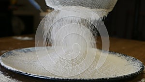 Slowmotion. Close-up of flour through a sieve fray. Sifting flour. Baking. Ingredients and preparation stages. Wheat