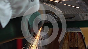 Slowmotion of metal processing with a man using angle grinder to cleaning steel