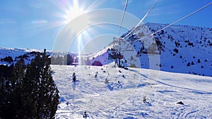 Slowmotion shot ski resort in the Pyrenees with skiers climbed on the ski lift to climb the mountain, Grandvalira