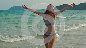 Slowmotion shot of a young beatyful woman having fun on a beach and in sea