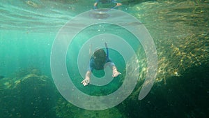 Slowmotion shot of a young man snorkeling and diving dip into sea. Showing ok under water