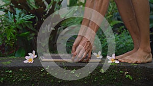 Slowmotion shot of a young man that using a Sadhu board or a nail board in a tropical surrounding