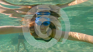 Slowmotion shot of a young woman snorkeling and having fun in a sea