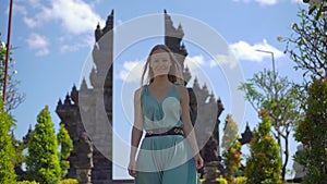 Slowmotion shot. Young woman tourist visits the Brahma Vihara Arama temple on the Bali island, Indonesia. Bali Travel