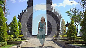 Slowmotion shot. Young woman tourist visits the Brahma Vihara Arama temple on the Bali island, Indonesia. Bali Travel