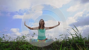 Slowmotion steadicam shot of a young woman doing meditation for Muladhara chakra in a Balinese way