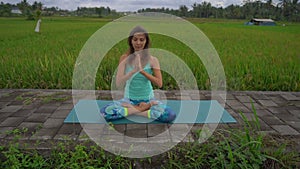 Slowmotion steadicam shot of a young woman doing meditation for Muladhara chakra in a Balinese way