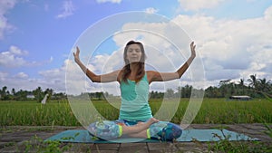 Slowmotion steadicam shot of a young woman doing meditation for Muladhara chakra in a Balinese way