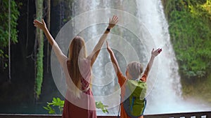 Slowmotion video. A woman and her son are portrayed as tourists visiting the breathtaking Upper Duden waterfall in the