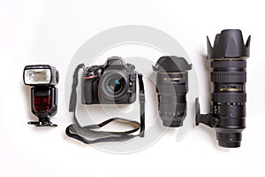 SLR camera, lenses and flash on white background