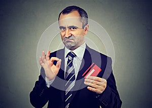Sly liar mature businessman employee reassuring their credit card is the best photo