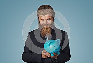 Sly Young man holding piggy bank plotting