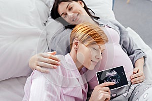 Sm iling woman holding ultrasound scan