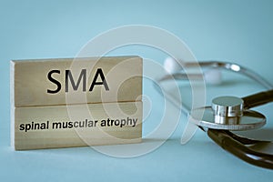 SMA Rare disease abbreviation Spinal Muscular Atrophy written on wooden blocks along with medical stethoscope, health concept,