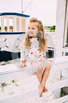 Smailing little girl enjoying sailing on a luxury yacht