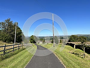 Smalden lane, with grass verges, old buildings and distant hills in, Grindleton, Clitheroe, UK