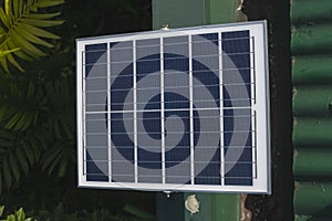 A small 50 watt Polycrystalline solar panel mounted on the edge of the roof of a house for an off-grid light